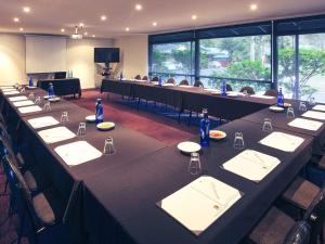 Mercure Alice Springs Resort في ينابيع أليس: قاعة اجتماعات مع طاولة طويلة مع كراسي