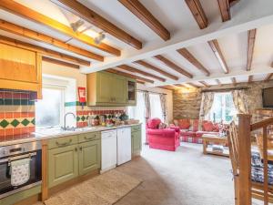 a kitchen with green cabinets and a living room at The Granary in Hawnby