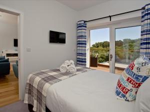 a bedroom with a bed and a sliding glass door at Dunlin 4 - The Cove in Brixham