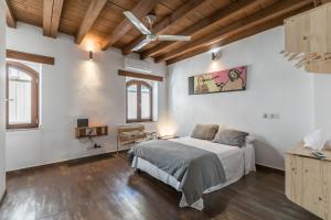 a bedroom with a bed and a ceiling fan at La Casa del Alfarero in Seville