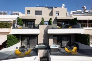 an apartment building with a patio with yellow chairs at LUX&EASY Athens Metro Suites in Athens