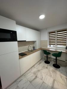 a kitchen with two green chairs and a sink at Exclusiv Room in Iaşi
