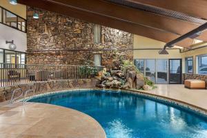 a swimming pool in a building with a stone wall at Travelodge by Wyndham Coffeyville in Coffeyville