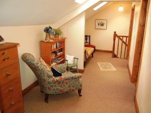 a living room with a chair and a bedroom at Elseghyll Barn in Melmerby