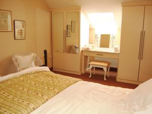 a bedroom with a bed and a dresser and a mirror at Elseghyll Barn in Melmerby