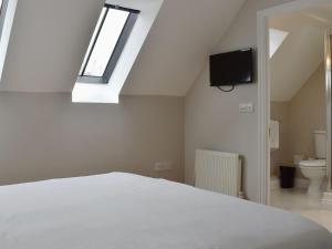 sypialnia z białym łóżkiem i świetlikiem w obiekcie Hollies Cottage 9 - Ukc4532 w mieście Martock