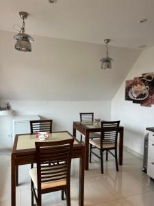 een eetkamer met 3 tafels en stoelen en een koelkast bij Pension-Geli in Monplaisir