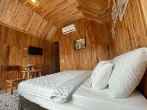 una camera da letto con un letto con soffitto in legno di My Tam Coc Bungalow a Ninh Binh