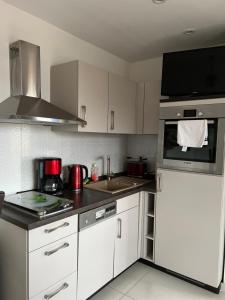 a kitchen with white cabinets and a stove top oven at Pension-Geli in Monplaisir