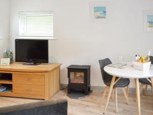 a living room with a table and a fire place at The Nest in Uny Lelant