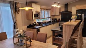 a kitchen with a table and a dining room at LUXURY LODGE on edge of New Forest and 800m from sea ENTERTAINMENT and LEISURE PASSES INCLUDED in Milford on Sea