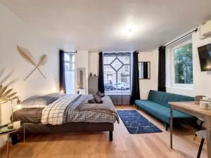 1 dormitorio con 1 cama y 1 sofá azul en Agathe en Rouen
