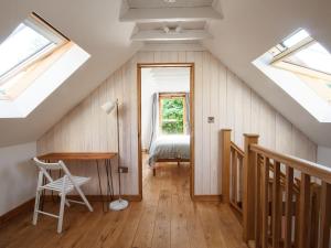 um quarto no sótão com uma cama e clarabóias em The Cider Barn em Flaxley