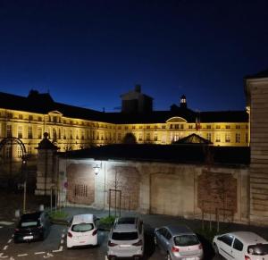 duży budynek z samochodami zaparkowanymi na parkingu w obiekcie Agathe w Rouen