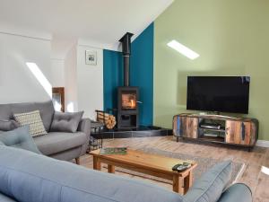 a living room with a couch and a flat screen tv at 1 Barnagh Barn in Kirkmichael