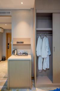 a kitchen with white clothes hanging on a closet at Livington Hotel in Stockholm