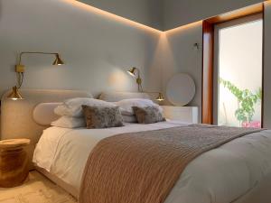 een slaapkamer met een bed met witte lakens en een raam bij CASA DOS OLIVAIS in Porto