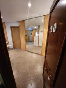 un pasillo vacío con una puerta de cristal y una habitación en eXperience Rooms Valencia, en Valencia