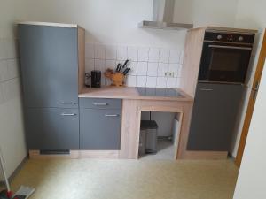 uma pequena cozinha com uma mesa e um frigorífico em Schöne Wohnung für Monteure und sonstige Reisende em Zwickau