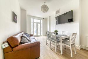 a living room with a couch and a table at A beautiful newly renovated home: The Arlingford in London