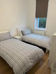 a bedroom with two beds and a window at A beautiful newly renovated home: The Arlingford in London