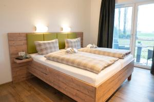 Duas camas num quarto com uma janela grande em Hotel Am Deich em Apen