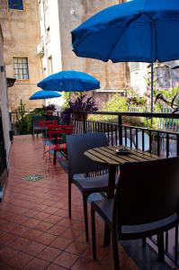 un patio con tavoli, sedie e ombrelloni blu di Trinacria apartments a Catania