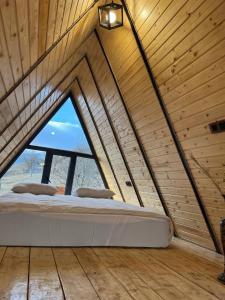 een groot bed in een kamer met een groot raam bij Triangle House in Dilidzjan