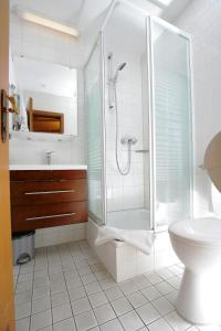 a white bathroom with a shower and a toilet at Hotel Drei Kaiserberge in Göppingen