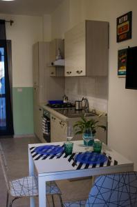eine Küche mit einem weißen Tisch und einer Arbeitsplatte in der Unterkunft Trinacria apartments in Catania