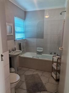 a bathroom with a tub and a toilet and a sink at Villa De Vie Self Catering Apartment in Brackenfell