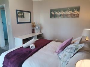 a bedroom with a bed with purple sheets and pillows at Villa De Vie Self Catering Apartment in Brackenfell