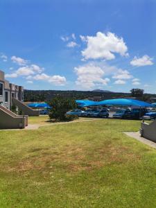a parking lot with parked cars and blue umbrellas at Villa De Vie Self Catering Apartment in Brackenfell