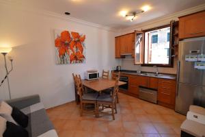 eine Küche mit einem Tisch und Stühlen sowie einem Tisch und eine Küche mit in der Unterkunft Villa Mar in Port de Valldemossa in Valldemossa