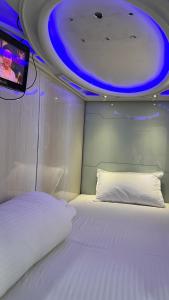 a bedroom with a white bed with a tv on the ceiling at Astropods in Mumbai