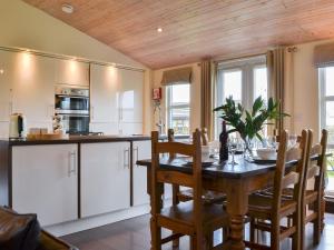 a kitchen and dining room with a wooden ceiling at Appletree Lodge in Wilberfoss