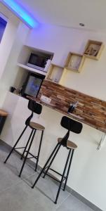 a bar with three stools in front of a counter at Wood 47 spa in Précy-sur-Oise