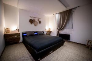 a bedroom with a black bed and a window at Wood 47 spa in Précy-sur-Oise