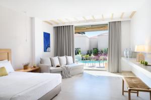 ein Schlafzimmer mit einem Bett und ein Wohnzimmer in der Unterkunft Cavo Delea Villas & Suites in Posidi