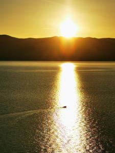a sun setting over a large body of water at Vila Verbana Apartments in Vrbnik