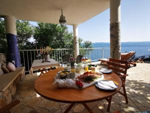 a table with food on it on a patio at Vila Verbana Apartments in Vrbnik
