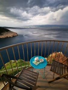 a table on a balcony with a view of the water at Vila Verbana Apartments in Vrbnik
