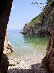 a view of the ocean from a cave in a cliff at Vila Verbana Apartments in Vrbnik
