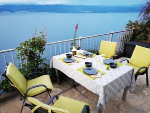 a table and chairs on a balcony with a view of the water at Vila Verbana Apartments in Vrbnik