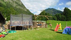 a playground in a field with a tent and play equipment at Haseltopf in Oberstdorf