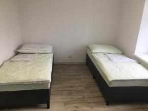 two twin beds in a room with at Apartmány U Hadiny in Humpolec