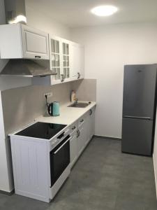 uma cozinha com armários brancos e um frigorífico preto em Apartmány U Hadiny em Humpolec