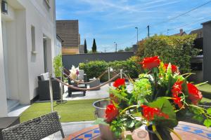 a patio with red flowers on a balcony at Suite avec piscine privée in Chelles