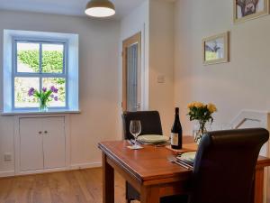 a dining room with a wooden table and a window at Little Cottage in Wigtown