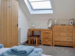 a bedroom with a desk and a bed and a skylight at Little Cottage in Wigtown